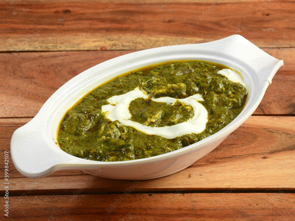 Palak Paneer Curry made up of spinach and cottage cheese, helathy indian traditional dish, served over a rustic wooden background, selective focus Palak Paneer Curry made up of spinach and cottage cheese, helathy indian traditional dish, served over a rustic wooden background, selective focus
