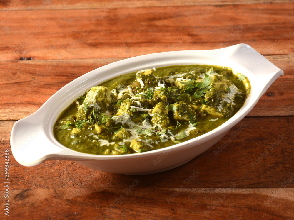 Palak Paneer Curry made up of spinach and cottage cheese, helathy indian traditional dish, served over a rustic wooden background, selective focus Palak Paneer Curry made up of spinach and cottage cheese, helathy indian traditional dish, served over a rustic wooden background, selective focus