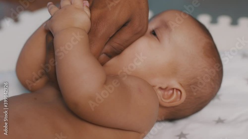 Close up black father tickling tummy of his newborn baby . Fatherhood and family. High quality 4k footage photo