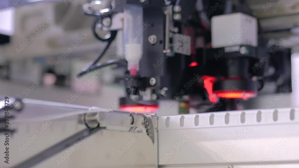 Assembly of computer circuit board - automatic SMD pick and place machine during work at factory - close up. Automated technology, industrial, robotic, electronic, production, manufacturing concept Assembly of computer circuit board - automatic SMD pick and place machine during work at factory - close up. Automated technology, industrial, robotic, electronic, production, manufacturing concept
