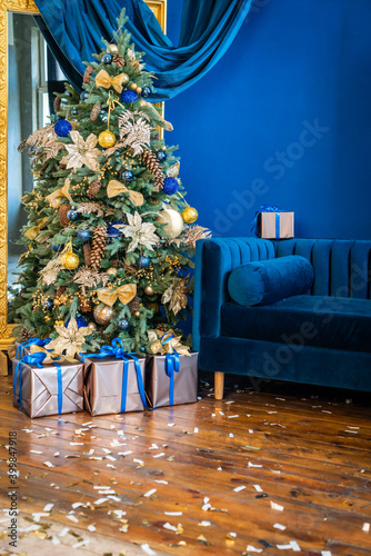Christmas background, living branches of spruce. Christmas decorations, Santa's mitten Pink and gold balls and Christmas bells. Festive background.