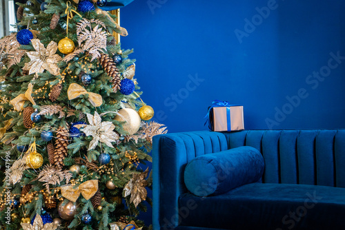 Christmas background, living branches of spruce. Christmas decorations, Santa's mitten Pink and gold balls and Christmas bells. Festive background.