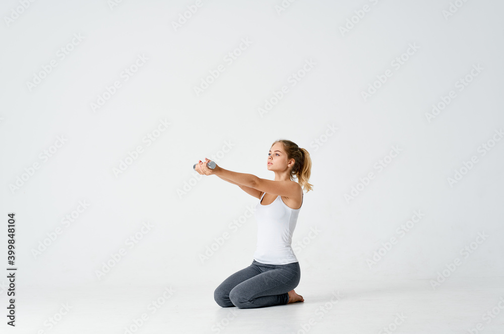 sportive woman with dumbbells in her hands sitting on the floor side view model sportive woman with dumbbells in her hands sitting on the floor side view model