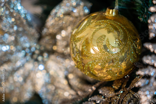 Christmas background, living branches of spruce. Christmas decorations, Santa's mitten Pink and gold balls and Christmas bells. Festive background.