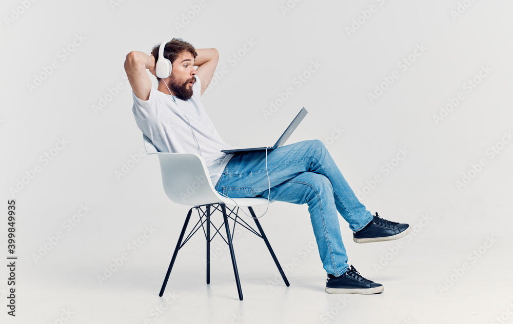 Man sitting on a chair in front of laptop headphones rest office internet technology Man sitting on a chair in front of laptop headphones rest office internet technology