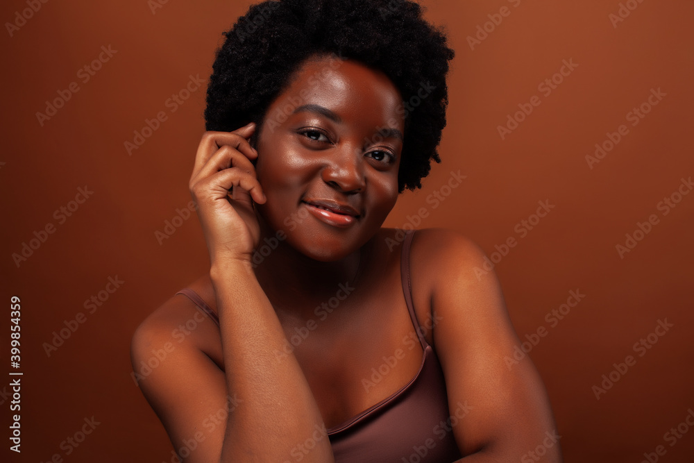 Fototapeta premium young pretty african model smiling happy on brown backround, lifestyle people concept
