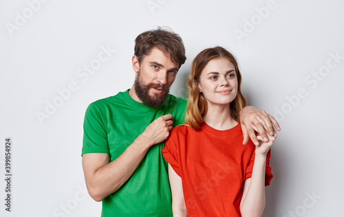 cute young couple in multicolored t-shirts hugs lifestyle fun isolated background