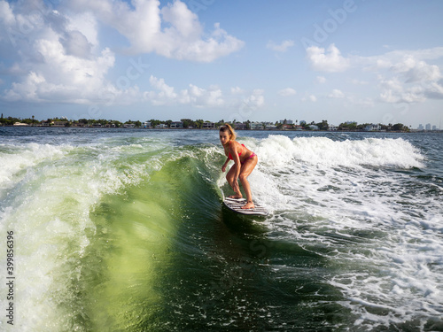 Female wake surfer riding wave in Miami intracoastal