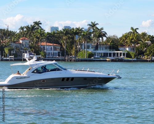 Sleek black and white motor yacht cruising by Rivo Alto island in Miami Beach,Florida.