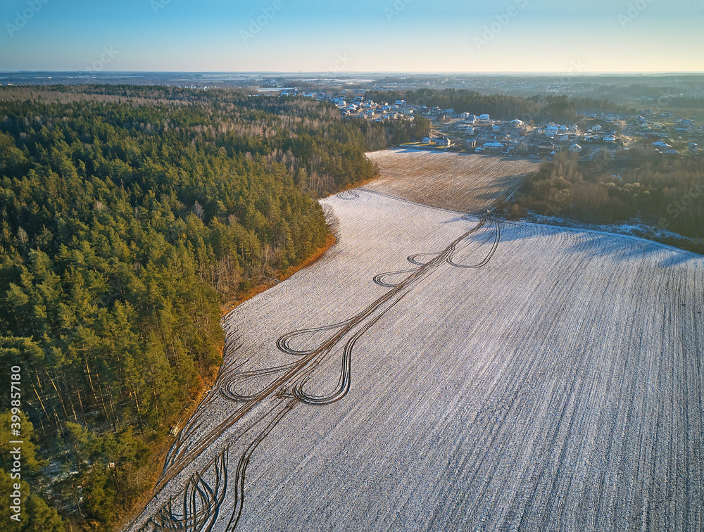 Winter Agricultural field under snow. Aerial scene. December Rural landscape.