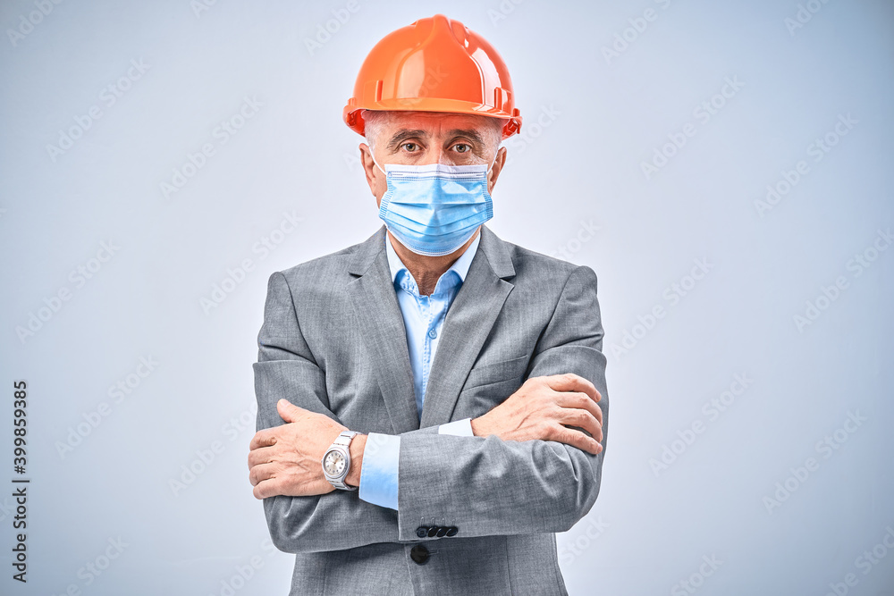 Adult boss wearing protective helmet and posing in studio Adult boss wearing protective helmet and posing in studio