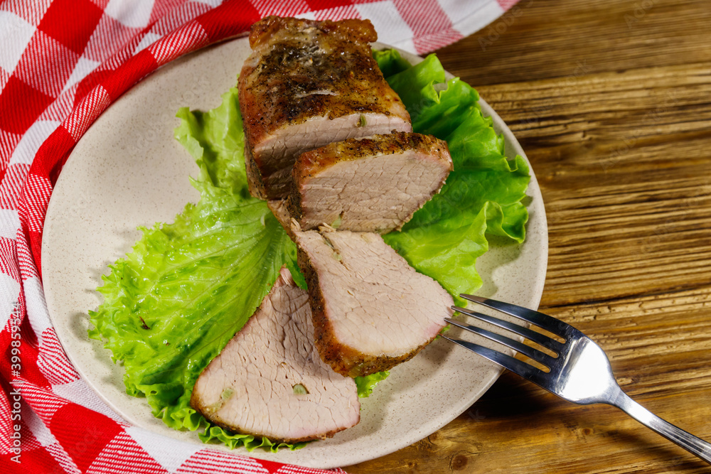 Tasty baked pork with spices on a wooden table Tasty baked pork with spices on a wooden table