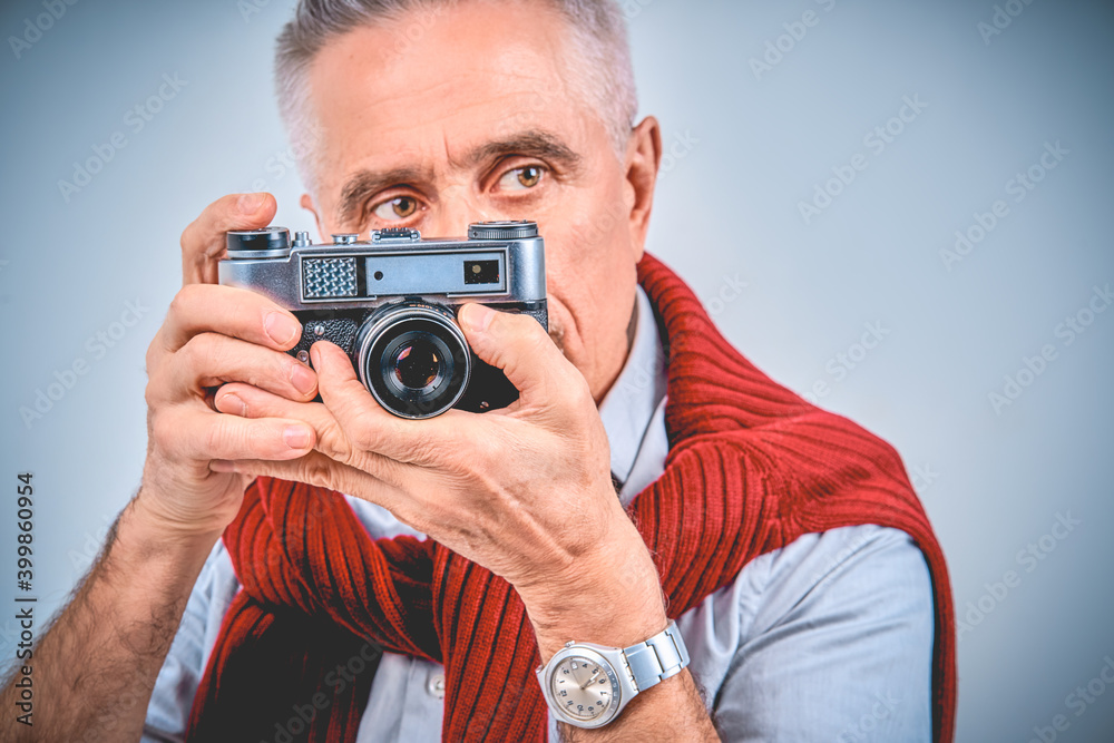 Focused male photographer while shooting on retro camera Focused male photographer while shooting on retro camera