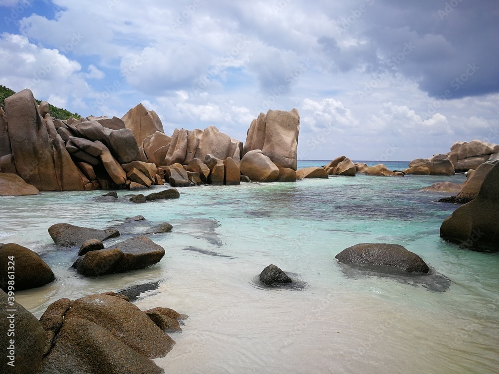 Obraz premium La Digue island beach with cliffs in Seychelles