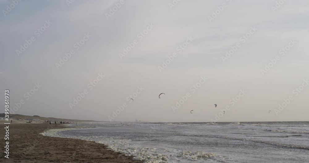 North sea coastline with kitesurfers in the background in sunset North sea coastline with kitesurfers in the background in sunset