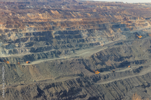 Huge iron ore quarry with working dump trucks and excavators © olyasolodenko
