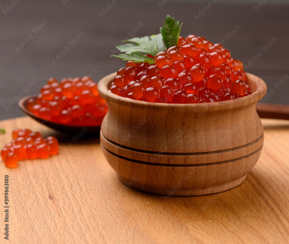 fresh grainy red chum salmon caviar in a wooden plate, delicious and healthy food fresh grainy red chum salmon caviar in a wooden plate, delicious and healthy food