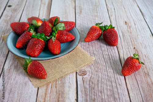 Strawberries in a bowl on top of a wooden table