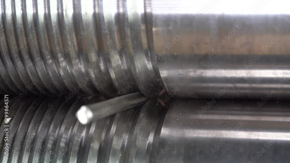 Jeweler makes thin silver metal wire with forge-rolls. Close up Jeweler makes thin silver metal wire with forge-rolls. Close up