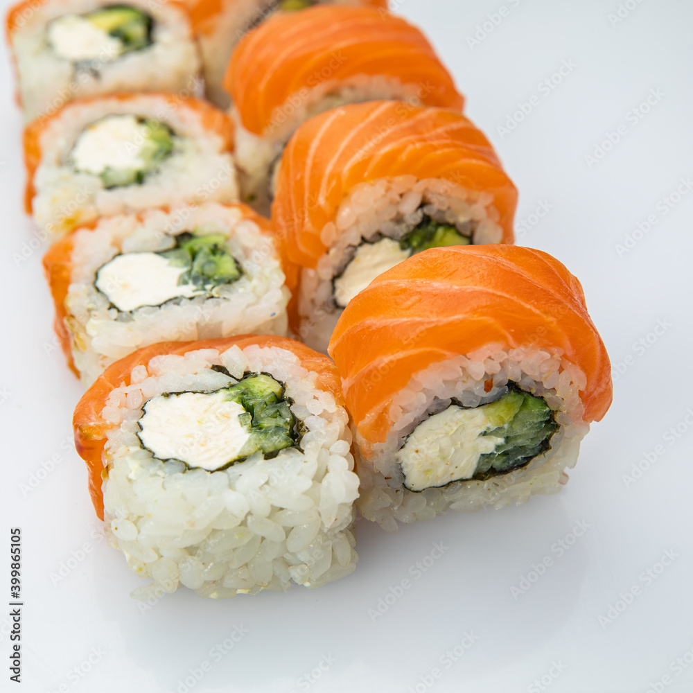 Japanese cuisine. Sushi roll with salmon on white background. Japanese cuisine. Sushi roll with salmon on white background.