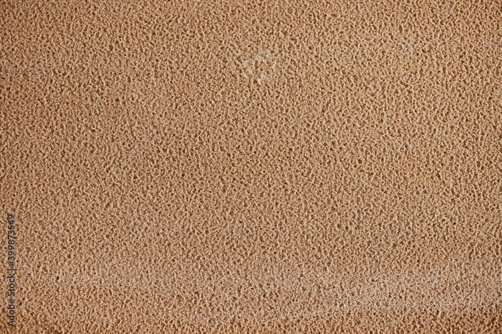 Obraz premium Closeup of a wavy texture of clean sand in the wind. A close-up of the wet texture of clean sand.