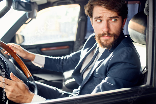 business man in suit driving a car trip luxury road