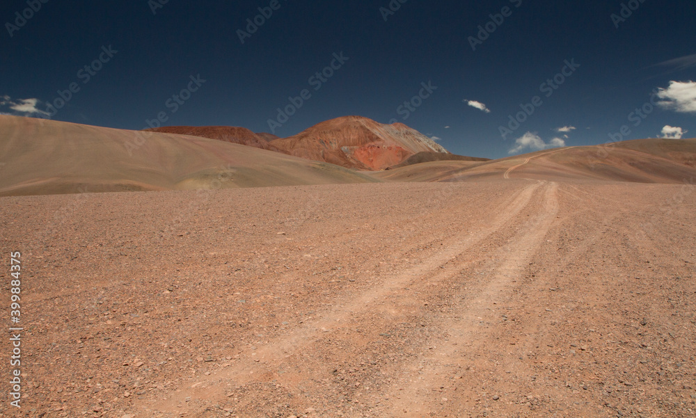 Adventure and explore. Traveling along the dirt road across the arid desert and mountains. View of the extreme route very high in the Andes cordillera. 