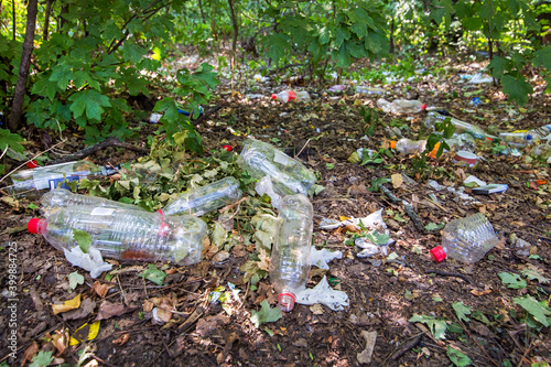 plastic bottles and plastic garbage in the forest on the ground pollutes nature, close-up of an ecological disaster closeup, nobody.