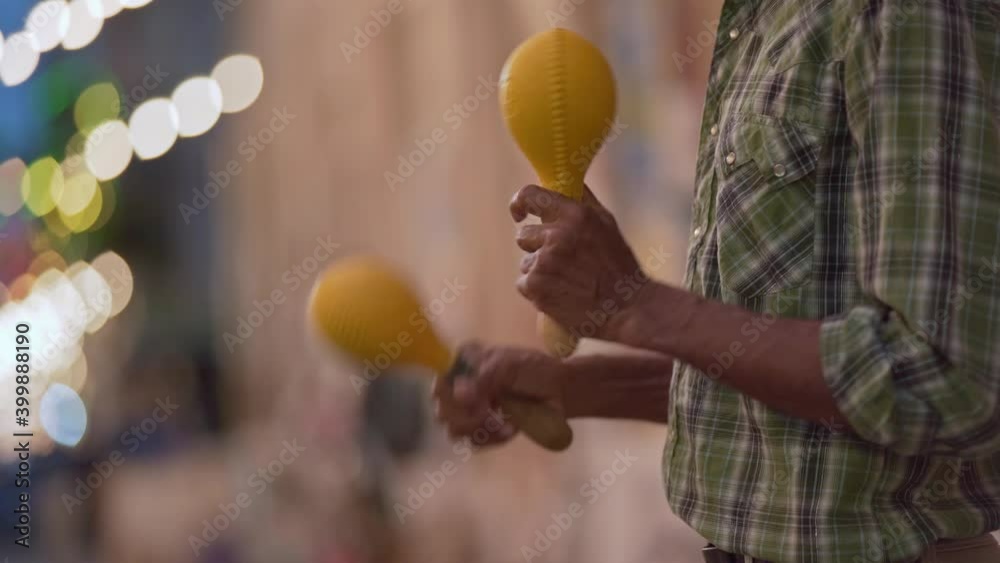 Man playing maracas as part of a band in the streets of Santo Domingo, close up shot