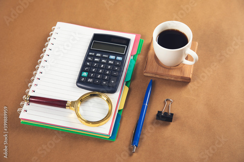 notepad with magnifier and calculator with coffee