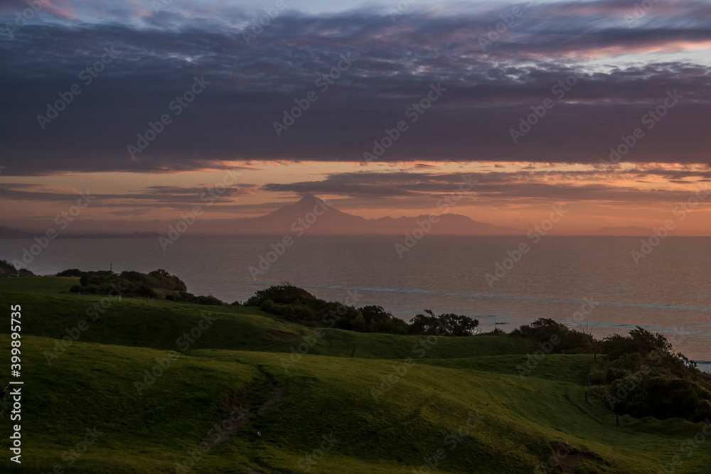 Mt Taranaki sunset view with ocean, clouds and greenland