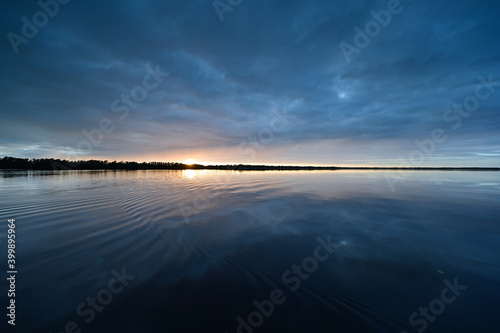 Winter cloudscape reflected in tranquil water of Coot Bay in Everglades National Park in late afternoon.