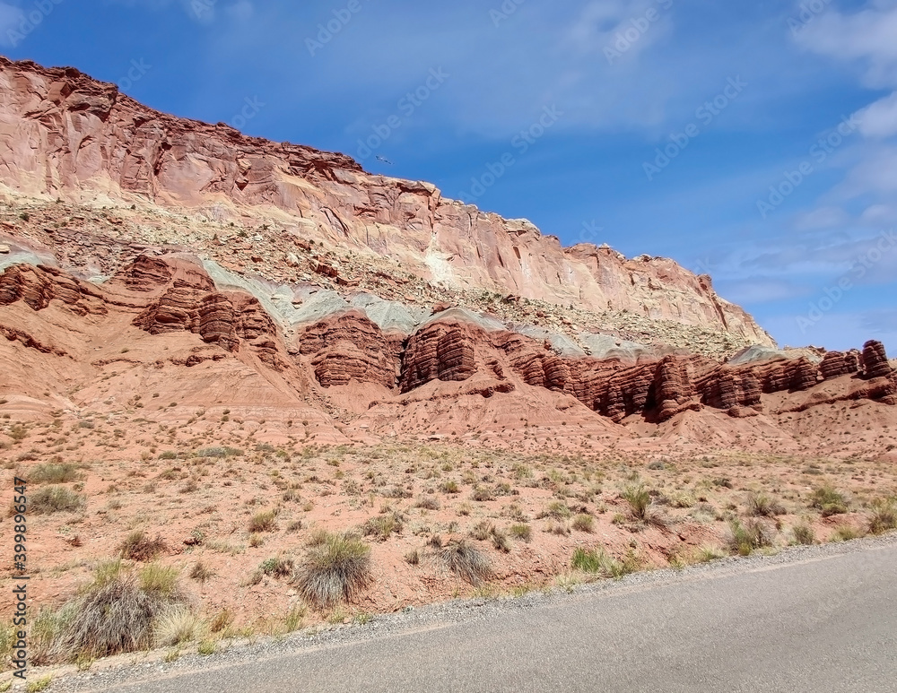 Sublime monoliths and towering sandstone cliffs on a hot partly cloudy summer day at Capitol Reef National Park in Southern Utah. Sublime monoliths and towering sandstone cliffs on a hot partly cloudy summer day at Capitol Reef National Park in Southern Utah.