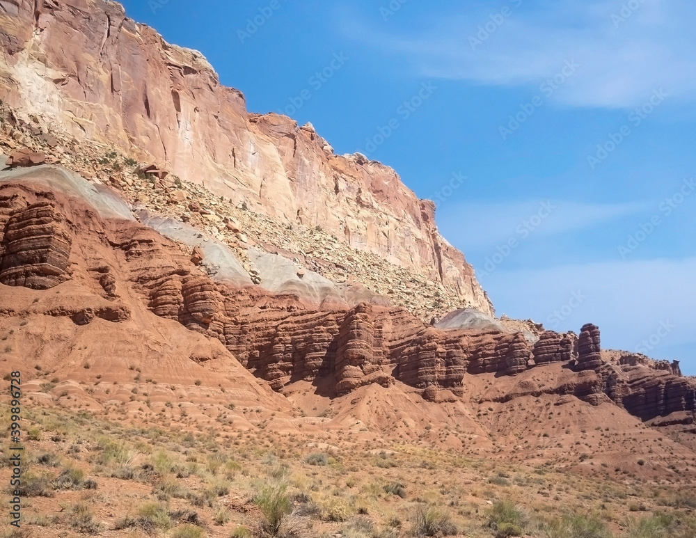 Sublime monoliths and towering sandstone cliffs on a hot partly cloudy summer day at Capitol Reef National Park in Southern Utah.
