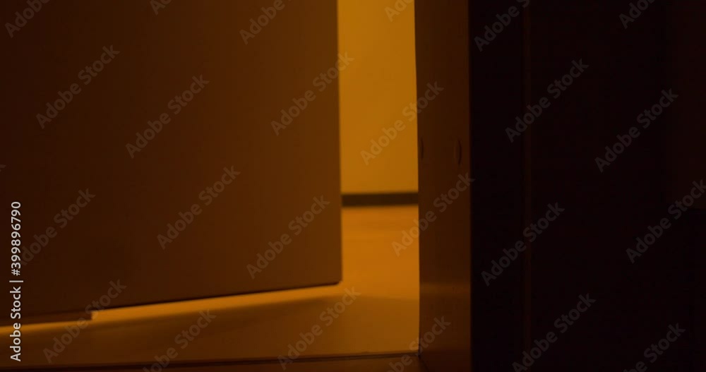 Close up of a closed wooden door slowly opening to reveal the the light and shadows on the exterior room. Close up of a closed wooden door slowly opening to reveal the the light and shadows on the exterior room.