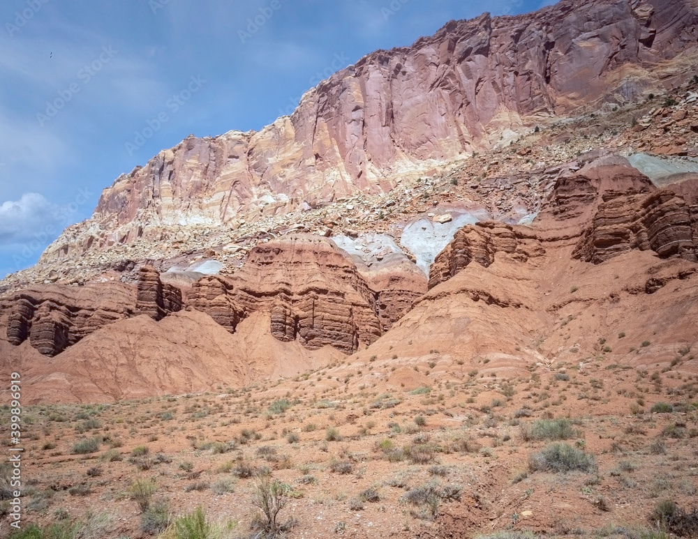 Sublime monoliths and towering sandstone cliffs on a hot partly cloudy summer day at Capitol Reef National Park in Southern Utah. Sublime monoliths and towering sandstone cliffs on a hot partly cloudy summer day at Capitol Reef National Park in Southern Utah.