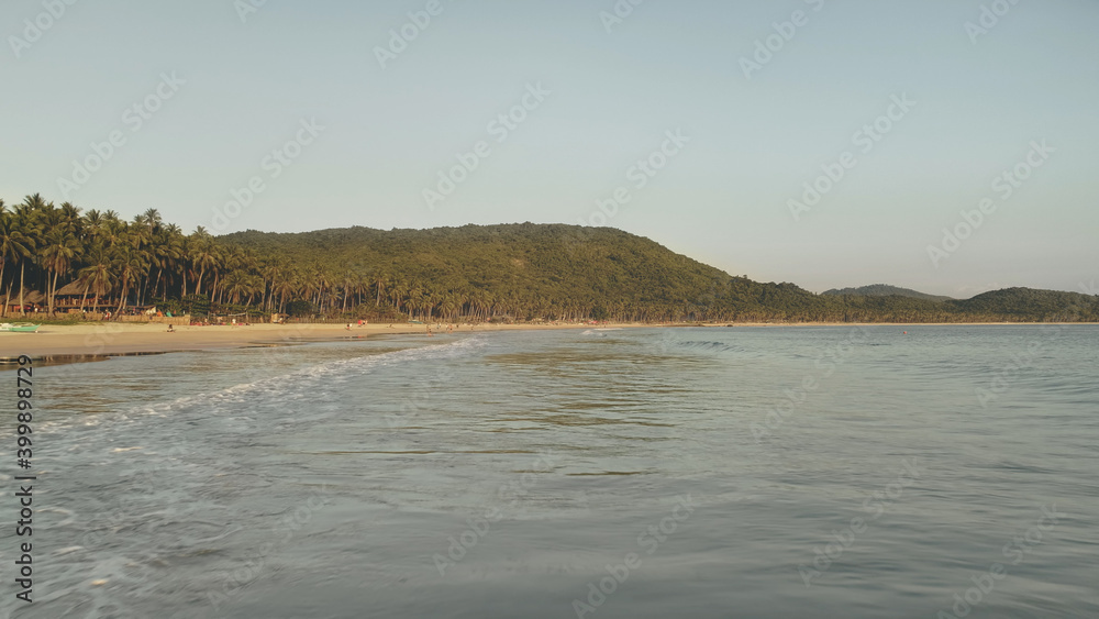 Ocean bay waves crash aerial. Nobody nature seascape with green sea coast. Greenery tropic forest at hills of El Nido Island, Philippines, Asia. Amazing summer vacation at tropic paradise