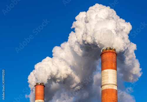 Emissions of smoke and steam from the pipes of the heating and power plant against the background of the blue sky in Moscow
 photo