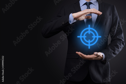 Fototapeta Naklejka Na Ścianę i Meble -  Targeting concept with businessman hand holding target icon dartboard sketch on chalkboard. Objective target and investment goal concept.
