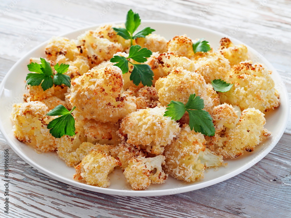 Cauliflower baked in breadcrumbs decorated with celery leaves.