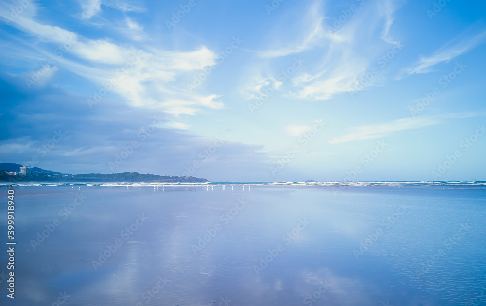 Evening view of the ocean with blue sky and cloud patterns and reflections.