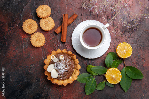 top view cup of tea with delicious cake and cookies on dark background sweet dessert biscuit