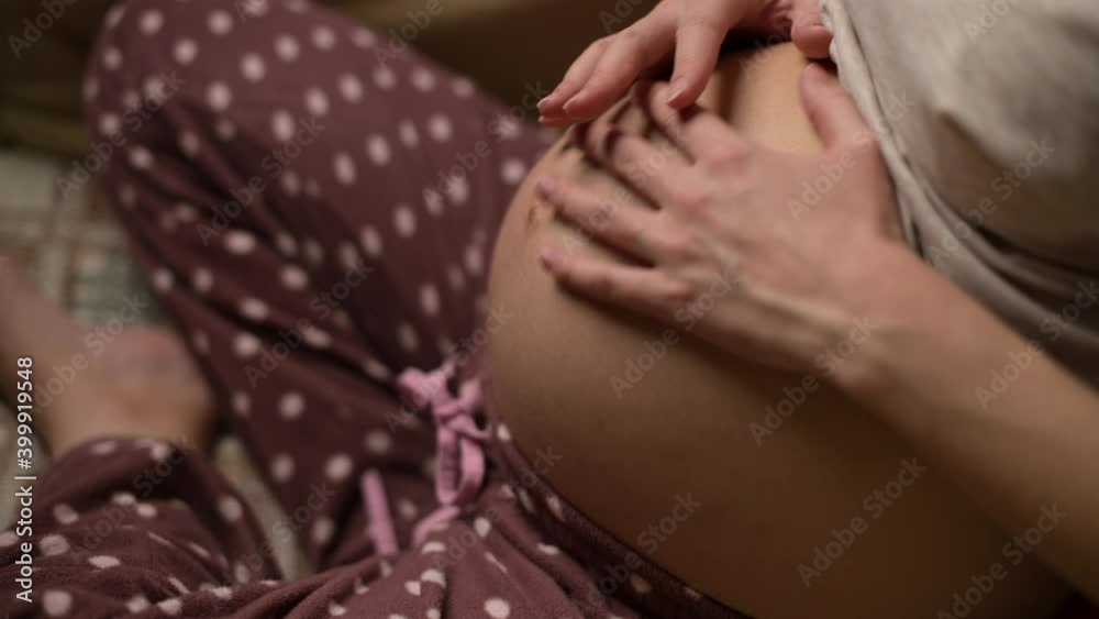 A pregnant woman stroking her belly in late pregnancy. Mother-to-be is expecting a baby