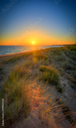 Fototapeta Naklejka Na Ścianę i Meble -  vu sur plage et une d'une d'herbe d'une ile en France au levé du soleil