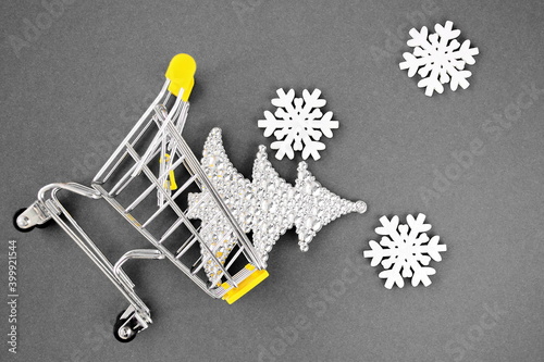 Christmas decorations snowflakes and Christmas tree fall from a small toy cart. Yellow and gray. Color trend of 2021. Happy New Year. The holiday is coming. New Year's Eve.