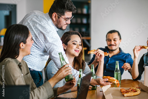 latin people coworkers eating pizza and drinking beer in office at Mexico city Happy Hour