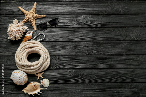 Composition with rolled rope and marine decor on dark wooden background