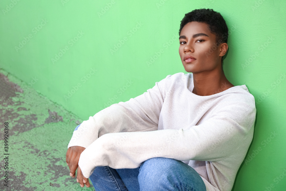 Obraz premium Stylish young African-American man near color wall