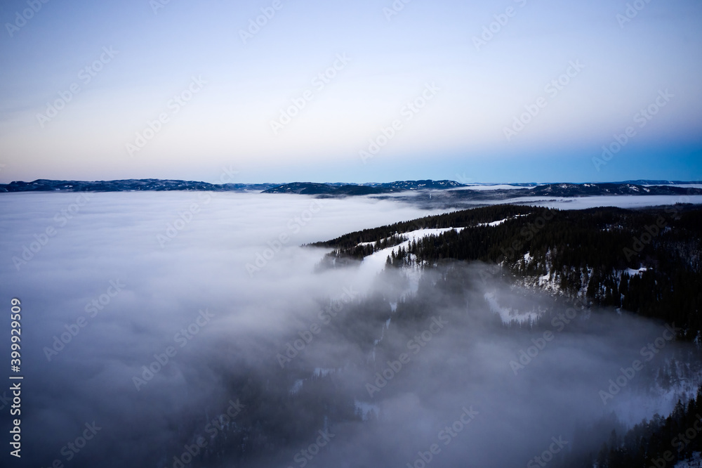 Obraz premium Arial: Photo shot with a drone. Fog in the valley below. Norway, Oslo, Holmenkollen.