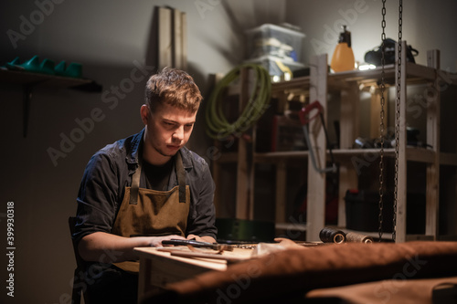 a young apprentice makes blanks for the production of shoes in the workshop